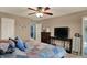 Bright bedroom showcasing a ceiling fan and an entertainment center with a large television at 594 N Shore Blvd, Franklin, IN 46131