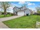View of a two-story home with well-kept lawn, a two-car garage, and blue sky above at 594 N Shore Blvd, Franklin, IN 46131