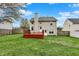 Home exterior with deck and spacious backyard that features mature trees and a full perimeter fence at 6064 Brandermill Rdg, Columbus, IN 47203