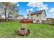 Backyard with firepit, deck and home, featuring a full perimeter fence and mature trees at 6064 Brandermill Rdg, Columbus, IN 47203