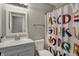 Cozy bathroom with a large vanity, neutral paint, and a colorful shower curtain at 6064 Brandermill Rdg, Columbus, IN 47203