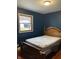 Cozy bedroom features a wooden bed frame and a large window with natural light at 6426 Maple Lawn Rd, Indianapolis, IN 46241