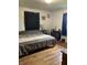 Bedroom featuring wood floors, curtains on the windows, and a dresser with decorations on it at 6426 Maple Lawn Rd, Indianapolis, IN 46241