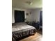 Bedroom featuring wood floors, curtains on the windows, and a dresser with decorations on it at 6426 Maple Lawn Rd, Indianapolis, IN 46241