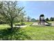Serene park view with a bench and playground in a lush green space for community enjoyment at 6518 Sonesta Dr, Indianapolis, IN 46217