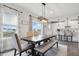 Bright dining area featuring a wooden table, upholstered chairs, bench seating, and modern light fixture at 7391 Blanford Dr, Plainfield, IN 46168