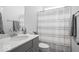 Bathroom with grey cabinets, white countertop, toilet and tiled shower at 745 Stone Trace Ct, Avon, IN 46123