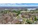 Expansive aerial view of a residential neighborhood showcasing lush greenery, a serene lake, and a tranquil landscape under a bright sky at 7469 Lion Dr, Nineveh, IN 46164