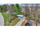 Charming blue cottage with a metal roof, gravel driveway, landscaped front, and surrounded by lush trees and vegetation at 7469 Lion Dr, Nineveh, IN 46164