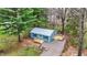 Charming blue cottage with a metal roof, and a gravel driveway surrounded by beautiful landscaping and mature trees at 7469 Lion Dr, Nineveh, IN 46164