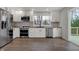Well-equipped kitchen featuring hardwood floors, stainless steel appliances, and white cabinets with modern countertops at 7469 Lion Dr, Nineveh, IN 46164