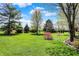 Lush backyard with manicured lawn, mature trees, and elegant landscaping, offering a private and picturesque setting at 7531 Normandy Blvd, Indianapolis, IN 46278