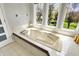 Bright bathroom with a soaking tub with jets and large windows overlooking a green yard at 7531 Normandy Blvd, Indianapolis, IN 46278