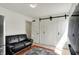 Bright living room featuring a black sofa and large white closet with sliding doors at 7531 Normandy Blvd, Indianapolis, IN 46278