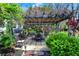 Backyard patio with shaded pergola surrounded by greenery and colorful flowers at 7531 Normandy Blvd, Indianapolis, IN 46278