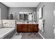 Bathroom with double sink vanity, large mirror, tiled floor, soaking tub, and decorative accents at 805 Harvest Lake Dr, Brownsburg, IN 46112
