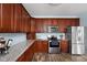 Charming kitchen with stainless steel appliances, granite countertops, and wood cabinets at 805 Harvest Lake Dr, Brownsburg, IN 46112