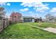 Fenced backyard offers green space and detached garage with a brick fire pit at 827 E Minnesota St, Indianapolis, IN 46203