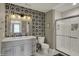 Stylish bathroom featuring double vanity, modern fixtures, black and white accent wall and glass enclosed shower at 827 E Minnesota St, Indianapolis, IN 46203