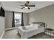 Comfortable bedroom featuring a large window, ceiling fan, and soft carpeted floor at 827 E Minnesota St, Indianapolis, IN 46203