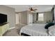 Comfortable bedroom includes a ceiling fan, dresser with tv, and cozy sitting area at 827 E Minnesota St, Indianapolis, IN 46203