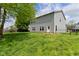 View of the home's backyard featuring a freshly cut lawn, gray siding, and natural light at 8404 Alcona Dr, Indianapolis, IN 46237