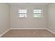 Neutral bedroom featuring two windows with blinds and neutral carpet at 8404 Alcona Dr, Indianapolis, IN 46237