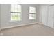 Bright bedroom with two windows, neutral carpet, and closet with paneled doors at 8404 Alcona Dr, Indianapolis, IN 46237