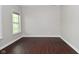 Minimalist bedroom features dark hardwood floors, neutral paint, natural light, and a modern aesthetic at 8404 Alcona Dr, Indianapolis, IN 46237