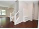 Welcoming foyer with hardwood floors, a staircase with white railings, and a convenient storage bench at 8404 Alcona Dr, Indianapolis, IN 46237