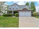Charming two-story home with a brick and gray siding facade, a two-car garage, and manicured landscaping at 8404 Alcona Dr, Indianapolis, IN 46237