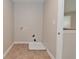 A compact laundry room with tile flooring, utility connections, and access to an outside view at 8404 Alcona Dr, Indianapolis, IN 46237