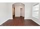 Living room featuring hardwood floors, white trim, a large window and an archway leading to another room at 8404 Alcona Dr, Indianapolis, IN 46237