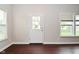 Bright living room features a door to the backyard and natural light from multiple windows and hardwood floors at 8404 Alcona Dr, Indianapolis, IN 46237