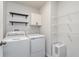 This laundry room features a washer and dryer, storage shelves, and decorative wallpaper at 846 Sunchaser Rd, Lebanon, IN 46052