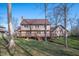 Backyard view of a house with a spacious deck and lush greenery on a sunny day at 9111 Sand Key Ln, Indianapolis, IN 46256