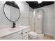 Bright bathroom featuring a modern vanity, circular mirror, and a glass-enclosed shower at 9111 Sand Key Ln, Indianapolis, IN 46256