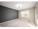 Bright bedroom with gray accent wall, neutral paint, plush carpeting, and natural light from large window at 9111 Sand Key Ln, Indianapolis, IN 46256