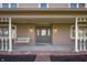 Charming front porch with swing, columns, brick foundation, and inviting entrance at 9111 Sand Key Ln, Indianapolis, IN 46256