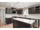Kitchen with dark cabinets, stainless steel appliances, and a center island with white countertop at 9111 Sand Key Ln, Indianapolis, IN 46256