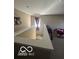 Hallway featuring plush carpeting, a window with decorative curtains, and access to living spaces at 9851 Pica Dr, Fishers, IN 46040