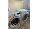 Modern laundry room featuring front-load washer and dryer with countertop covers at 9851 Pica Dr, Fishers, IN 46040