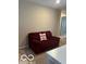 Cozy living room with a comfortable red loveseat and neutral carpet at 9851 Pica Dr, Fishers, IN 46040