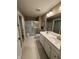 Well-lit bathroom with double sink vanity, tile flooring, and glass enclosed shower at 99 Gnarled Oak Ln, Whiteland, IN 46184
