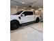 View of a truck parked inside a well-lit garage with a concrete floor and an automatic overhead door system at 99 Gnarled Oak Ln, Whiteland, IN 46184