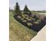 Professionally landscaped garden featuring sod, mature trees, and freshly mulched planting beds at 99 Gnarled Oak Ln, Whiteland, IN 46184