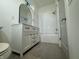 Well-lit bathroom featuring a vanity with storage and a bathtub with tile surround at 1038 St Peter St, Indianapolis, IN 46203