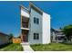 Contemporary home with a modern design, red front door, a small balcony, and green grass at 1038 St Peter St, Indianapolis, IN 46203
