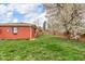 Spacious backyard with green grass and a flowering tree, surrounded by a wooden fence at 1061 N Layman Ave, Indianapolis, IN 46219