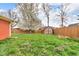 Lawn with a wooden fence surrounding a well maintained backyard and an old storage shed at 1061 N Layman Ave, Indianapolis, IN 46219